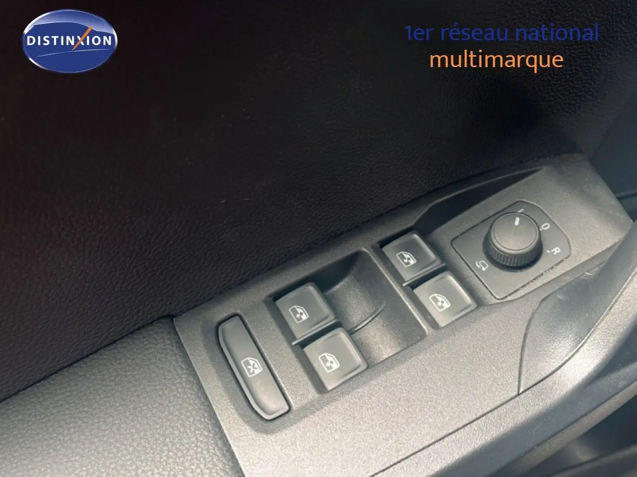 Gros plan sur les commandes des vitres et rétroviseurs côté conducteur d'une SEAT Arona bleu saphir avec toit noir.