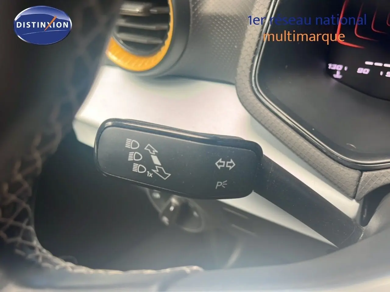 Gros plan sur la manette de clignotant côté gauche du tableau de bord du SEAT Arona 2025 bleu saphir métal avec toit noir.