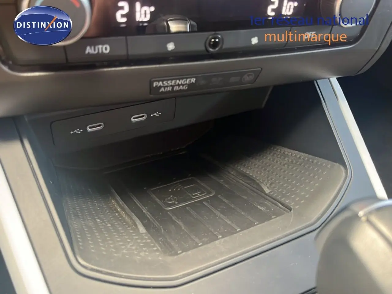 Vue rapprochée de la console centrale du SEAT Arona 2025, montrant les ports USB et le chargeur sans fil.