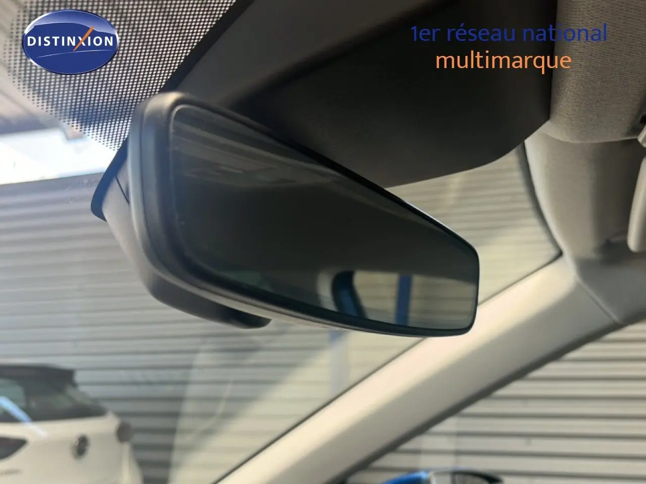 Rétroviseur intérieur en gros plan de la SEAT Arona bleu saphir métal avec toit noir, vue depuis l'habitacle côté conducteur.