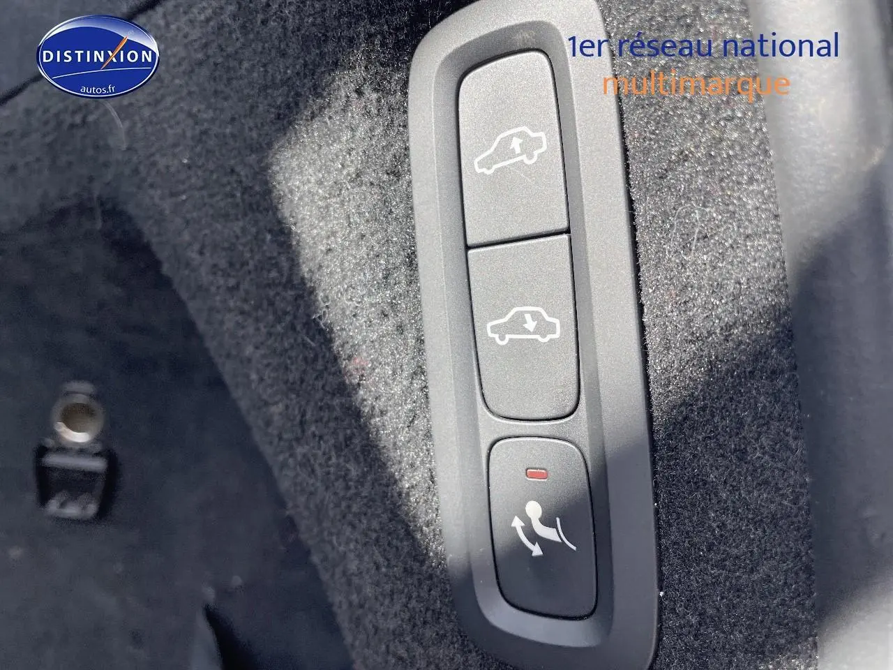 Gros plan sur les commandes d'ouverture et fermeture du coffre dans l'habitacle d'un Volvo XC90 gris.