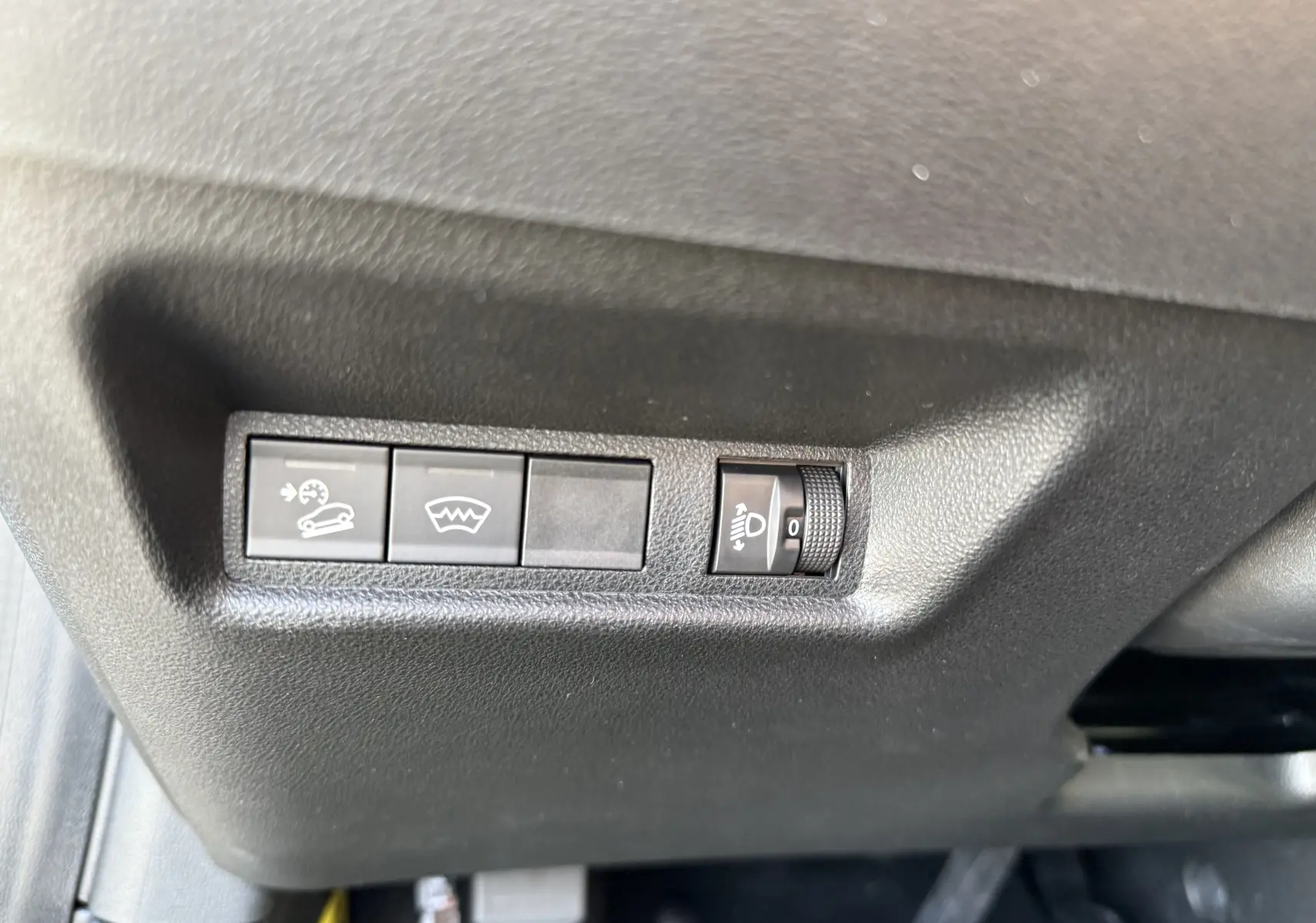 Gros plan sur les commandes de réglage d’éclairage et d’assistance au conducteur dans l’habitacle du Jeep Avenger 2025.