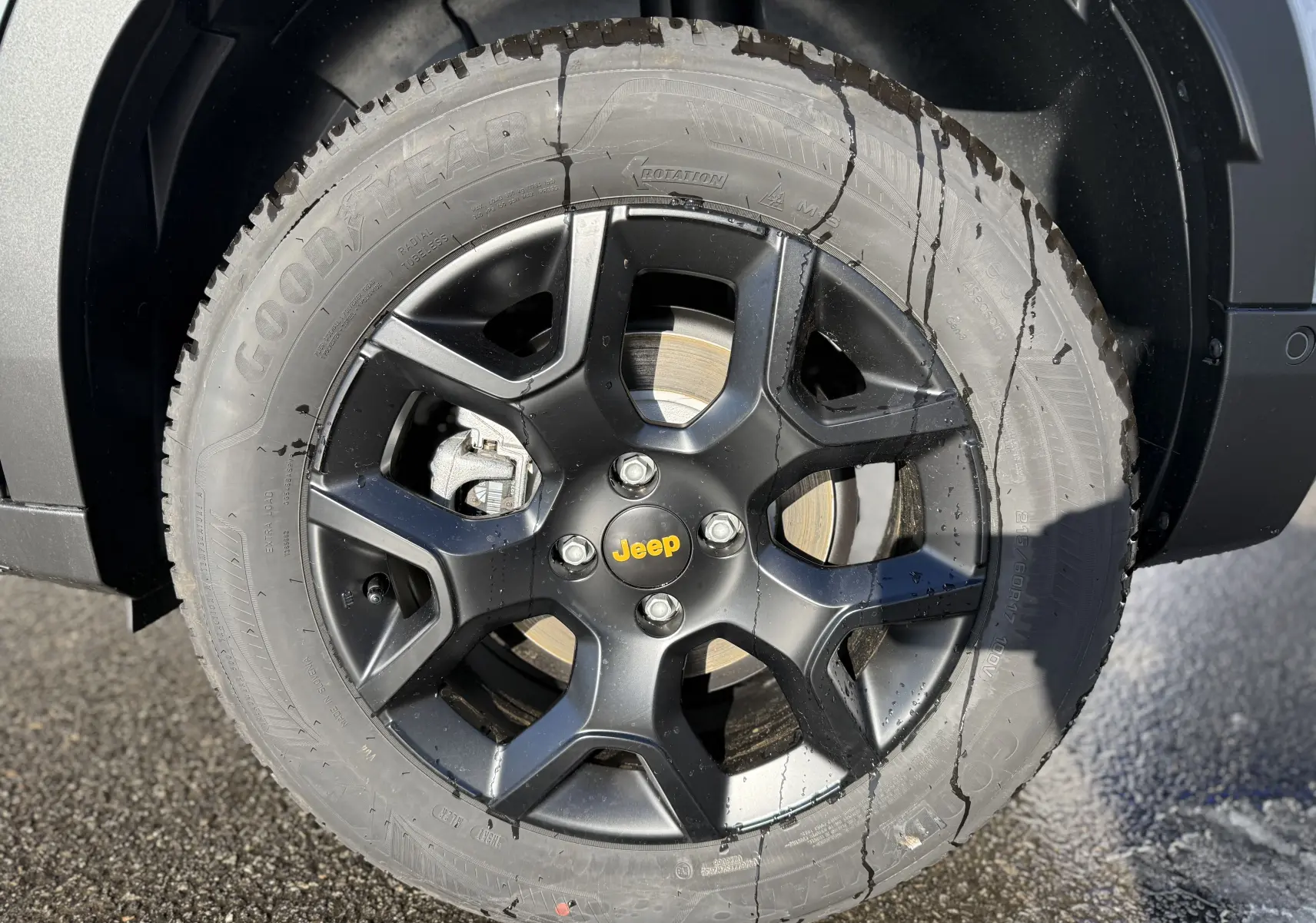 Gros plan sur la roue avant droite noire avec logo Jeep jaune du Jeep Avenger Storm Grey 2025.