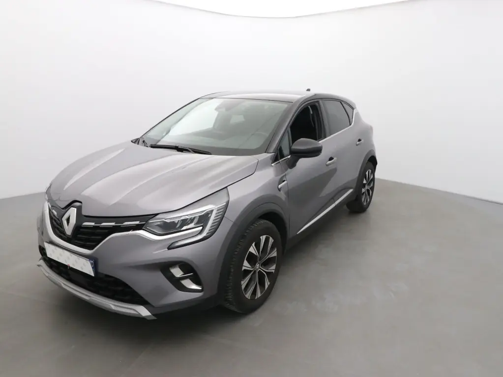 Renault Captur 2024 gris cassiope et noir, vue 3/4 avant droit, avec jantes alliage et feux LED distinctifs.