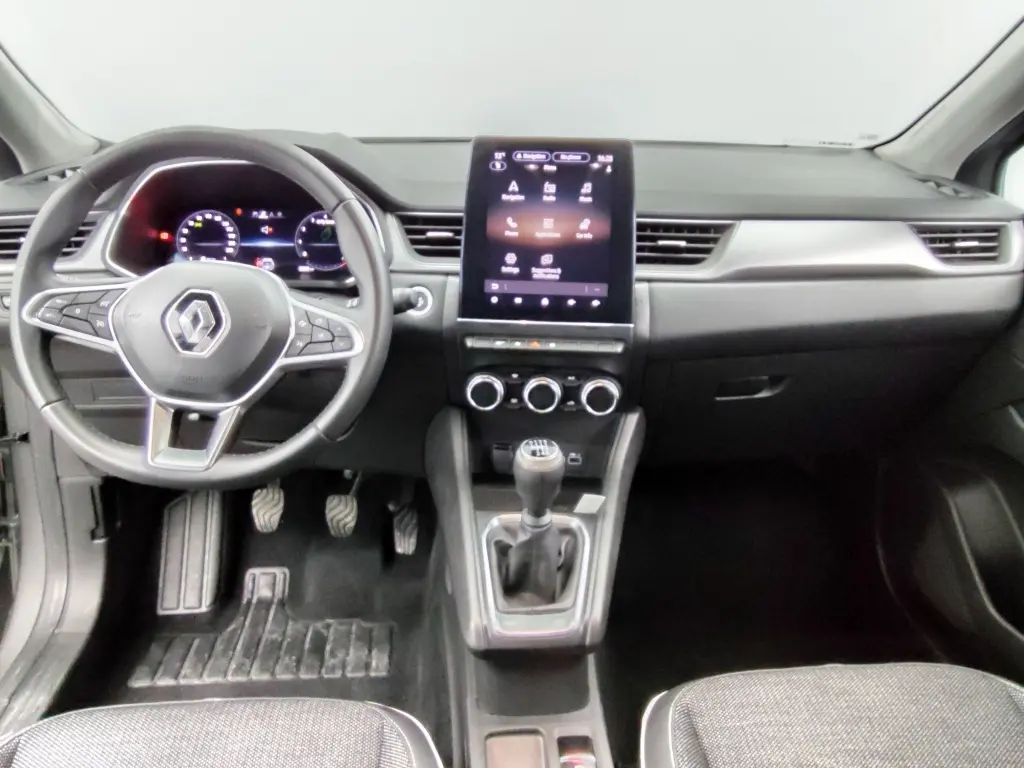 Vue intérieure avant du Renault Captur 2024 essence gris cassiope, volant multifonction et écran tactile central vertical.