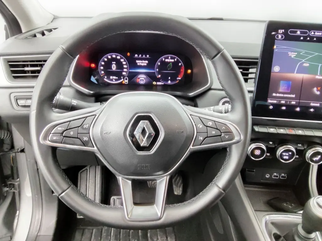 Vue intérieure centrée sur le volant noir du Renault Captur 2024 avec tableau de bord numérique et écran tactile.