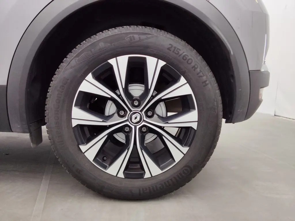 Gros plan sur la roue avant gauche du Renault Captur 2024 gris Cassiope avec jante alliage bicolore distinctive.