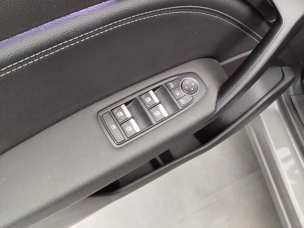 Gros plan sur la commande des vitres électriques et réglage des rétroviseurs sur la porte côté conducteur du Renault Captur gris cassiope.