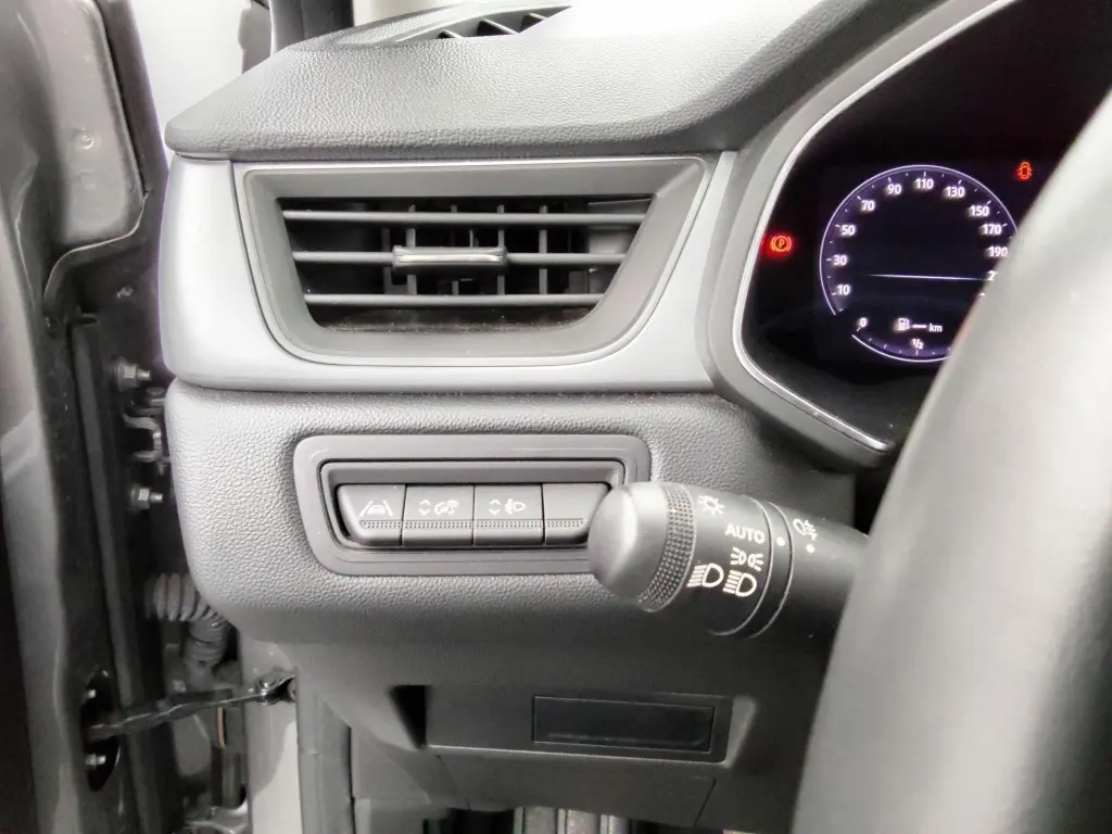 Détail intérieur côté gauche du tableau de bord du Renault Captur 2024 gris cassiope, avec commandes d'assistance et ventilation.