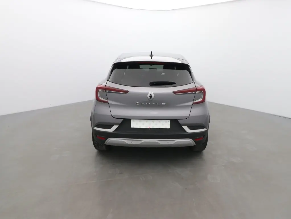 Vue arrière d’un Renault Captur 2024 gris cassiope avec toit noir, feux LED et logo central visible.