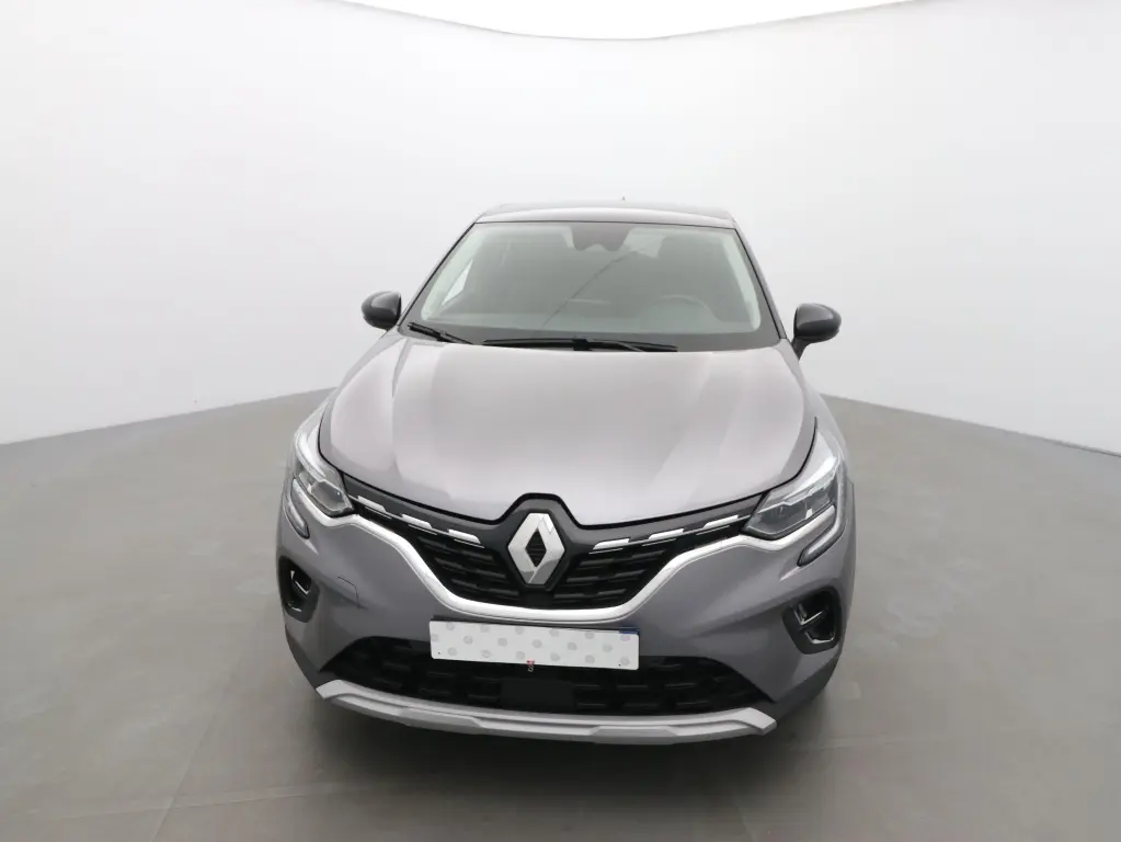 Vue avant d'un Renault Captur 2024 gris cassiope avec toit noir, mettant en valeur sa calandre distinctive et ses phares LED.