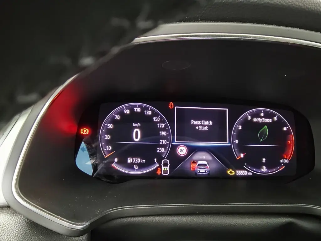 Vue rapprochée du tableau de bord numérique du Renault Captur 2024, affichant la vitesse à 0 km/h et l'invite "Press Clutch + Start".