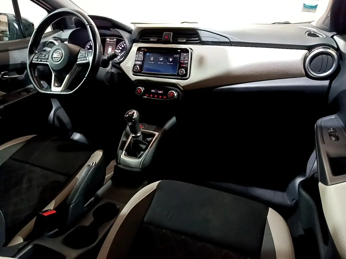 Vue intérieure avant droite de la Nissan Micra IG-T 90 N-Connecta 2017, volant cuir, écran tactile et levier de vitesses manuel.