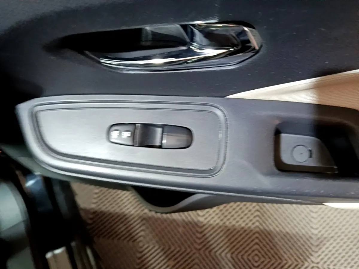 Gros plan sur la commande de réglage des rétroviseurs côté conducteur de la Nissan Micra IG-T 90 N-Connecta noire.