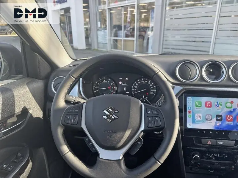 Vue intérieure frontale du volant cuir multifonction noir du Suzuki Vitara avec tableau de bord et écran tactile couleur.