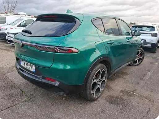 Vue 3/4 arrière droite d'une Alfa Romeo Tonale 1.5 MHEV 130 vert foncé avec jantes distinctives à cinq branches.