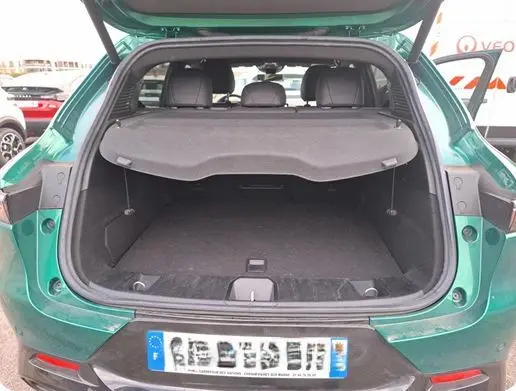 Coffre ouvert d'une Alfa Romeo Tonale 1.5 MHEV vert foncé, vue arrière mettant en valeur l'espace de chargement et l'intérieur noir.