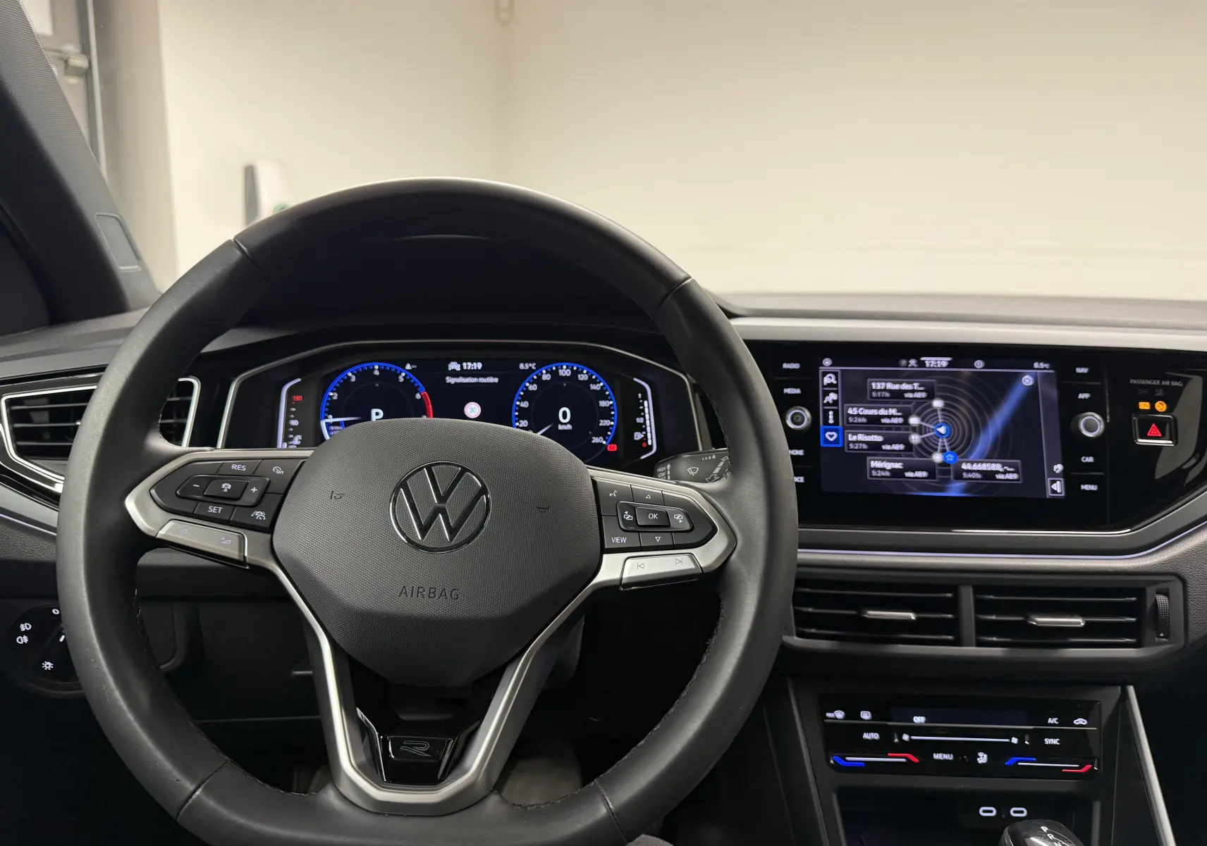 Vue intérieure centrée sur le volant cuir multifonctions et le tableau de bord digital du Volkswagen Taigo gris cendre.