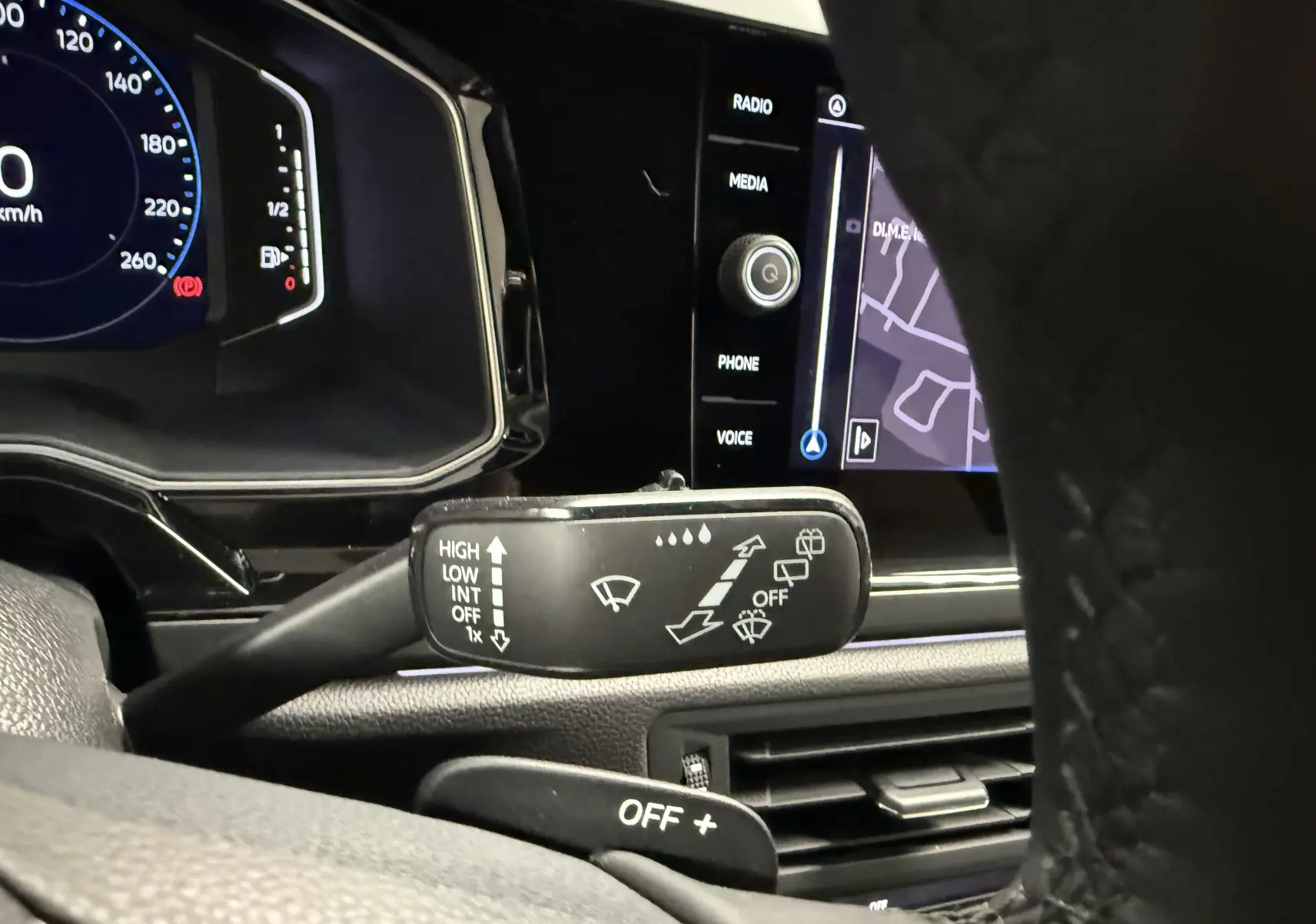 Gros plan intérieur sur la commande d’essuie-glace et le tableau de bord numérique du Volkswagen Taigo gris cendre.