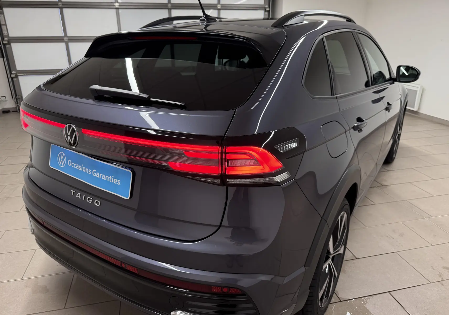 Vue 3/4 arrière droite du Volkswagen Taigo gris cendre avec feux arrière LED et jantes alliage 18 pouces Misano.