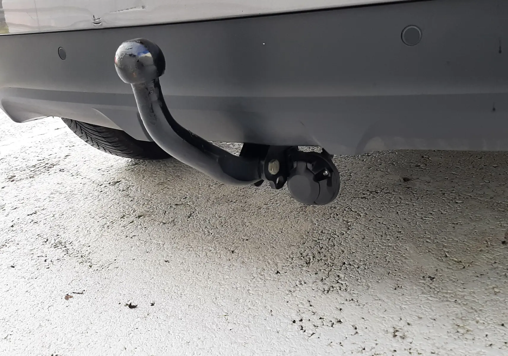 Vue arrière d'un Renault Scenic IV gris Cassiopée avec toit noir, feux arrière allongés et attelage visible.