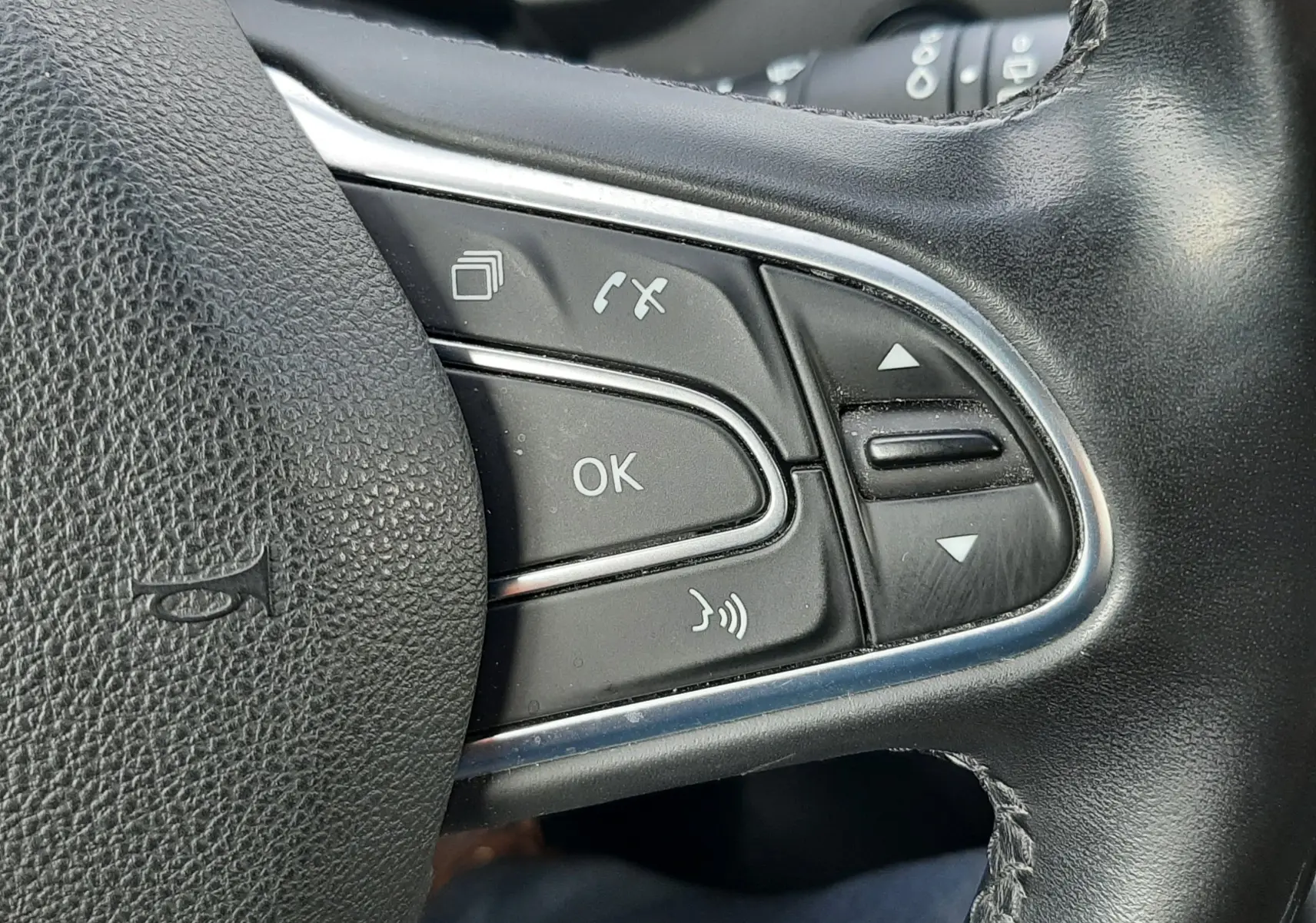 Gros plan sur les commandes noires du volant en cuir noir du Renault Scenic IV 2020, version diesel.