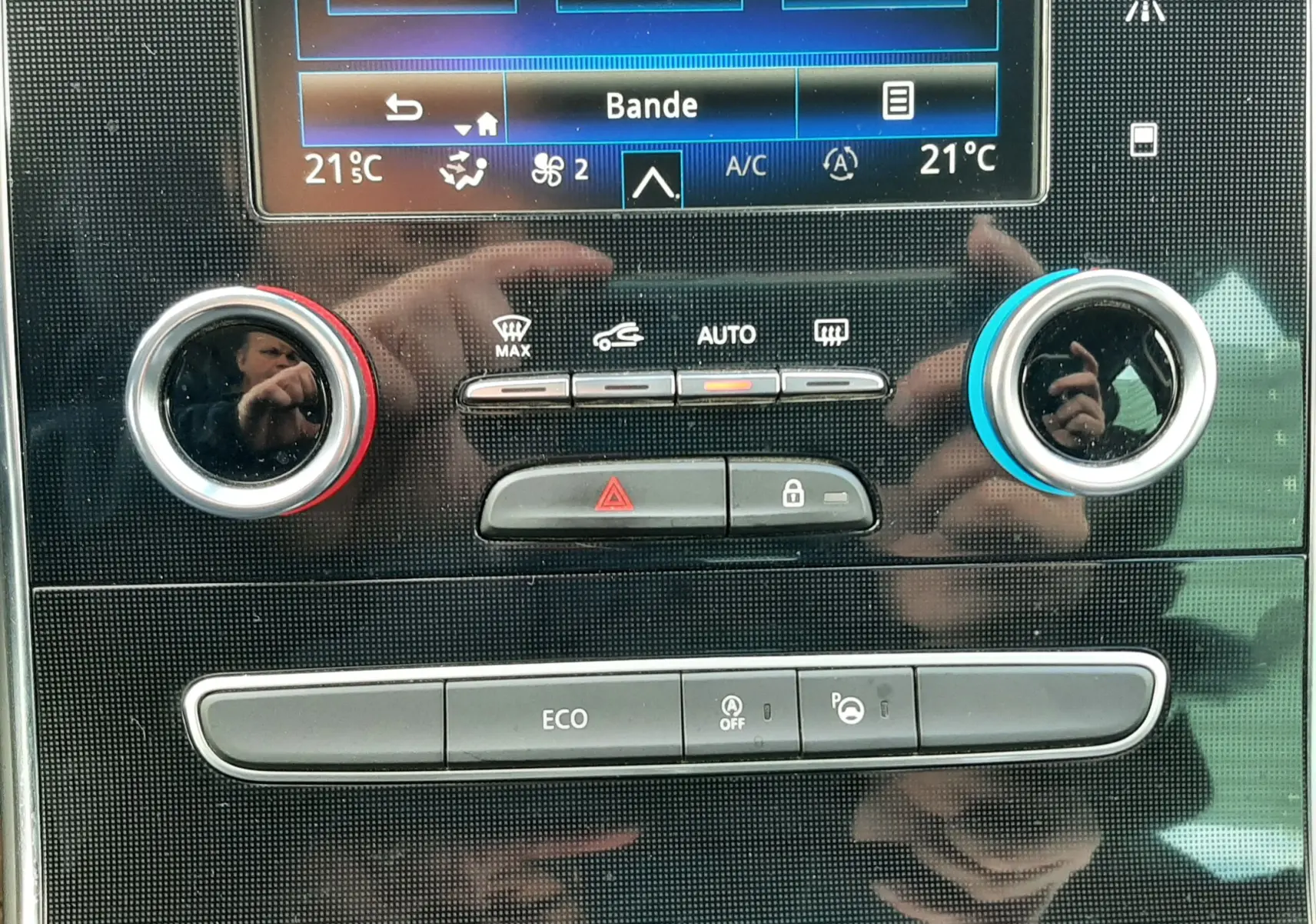 Gros plan sur le levier de vitesses manuel argenté du Renault Scénic IV, entouré de commandes noires.