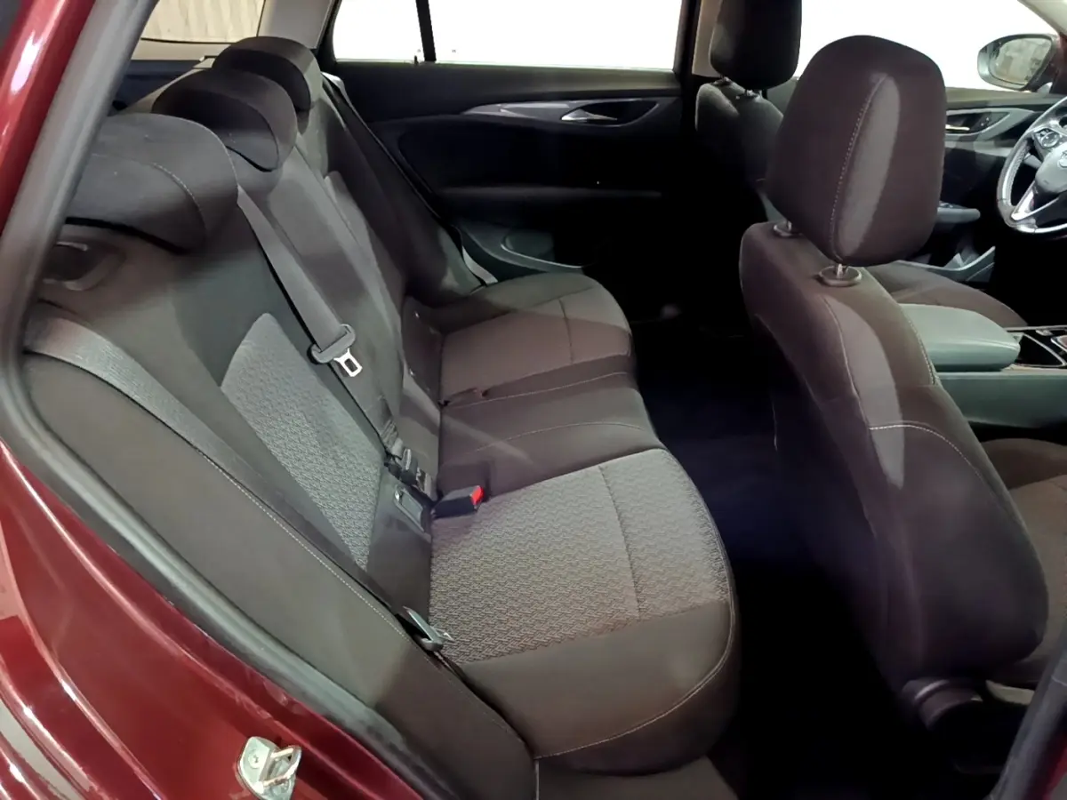 Vue intérieure côté gauche montrant les sièges arrière gris foncé de l’Opel Insignia rouge édition Business 2019.