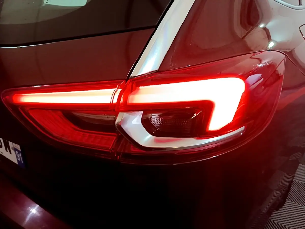 Gros plan sur le feu arrière droit rouge allumé d’une Opel Insignia rouge, finition Edition Business 2019.