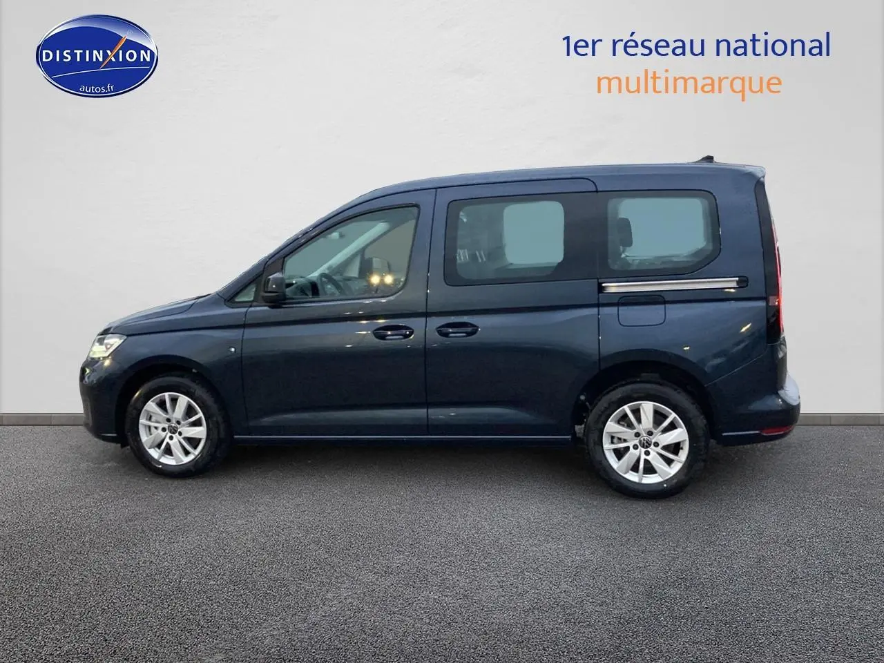 Profil côté gauche d'un Volkswagen Caddy bleu métallisé 2025 avec jantes alliage et vitres teintées arrière.