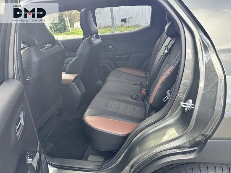 Vue intérieure arrière côté droit du Suzuki Vitara 2026, sièges tissu/cuir noir et marron, porte ouverte.