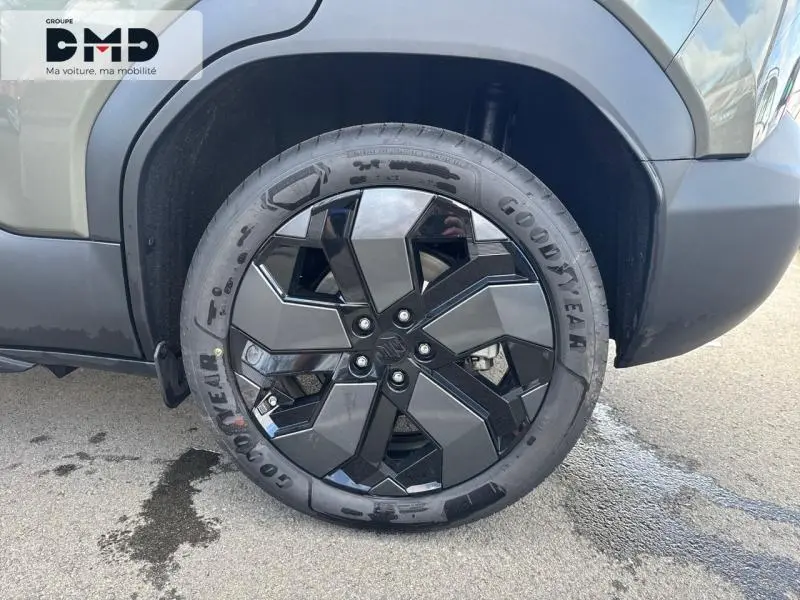 Gros plan sur la roue avant gauche du Suzuki Vitara 2026 vert Land Breeze avec jante alu noire et grise au design géométrique.