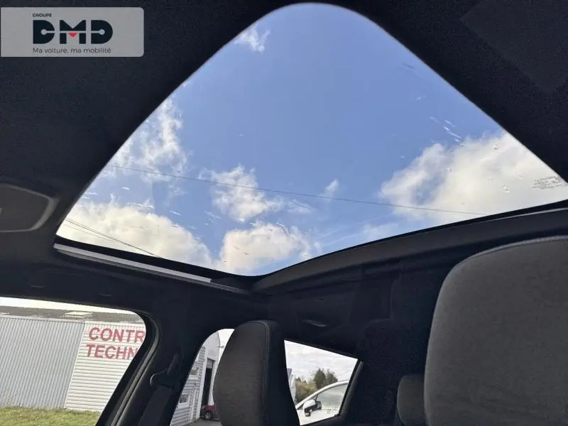Vue intérieure du toit panoramique en verre du Suzuki Vitara 2026, avec ciel bleu visible à travers le toit noir.