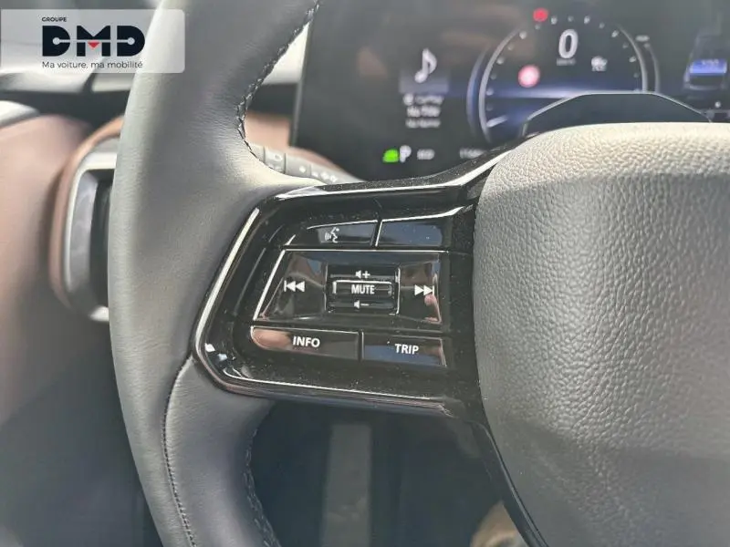 Gros plan sur les commandes audio au volant noir du Suzuki Vitara 2026, intérieur cuir noir et marron visible en arrière-plan.