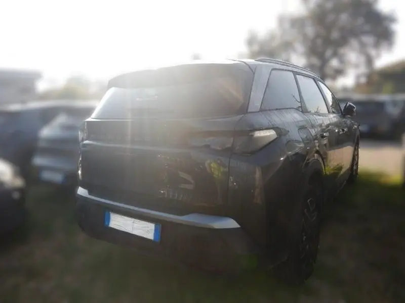Vue 3/4 arrière droite d’un Peugeot 5008 gris 2025 avec feux arrière LED et toit noir brillant.