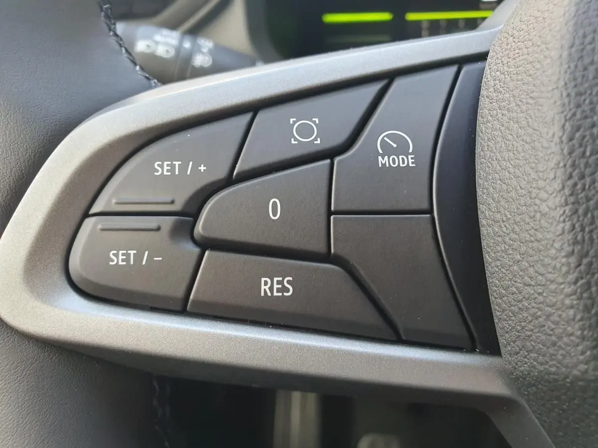 Gros plan sur les commandes de régulateur de vitesse au volant du Dacia Dokker Van gris schiste, version 2026.