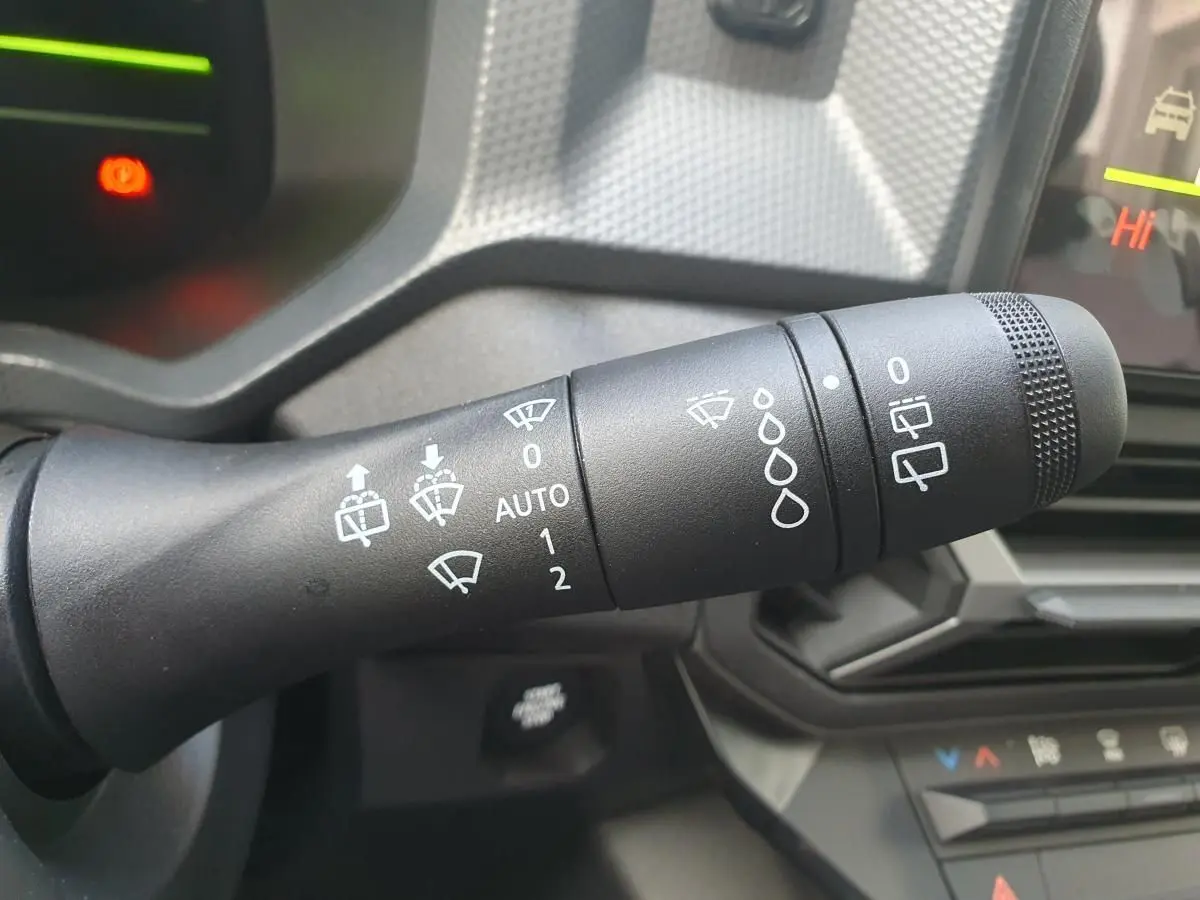 Gros plan sur la commande des essuie-glaces du tableau de bord intérieur du Dacia Dokker Van gris schiste 2026.
