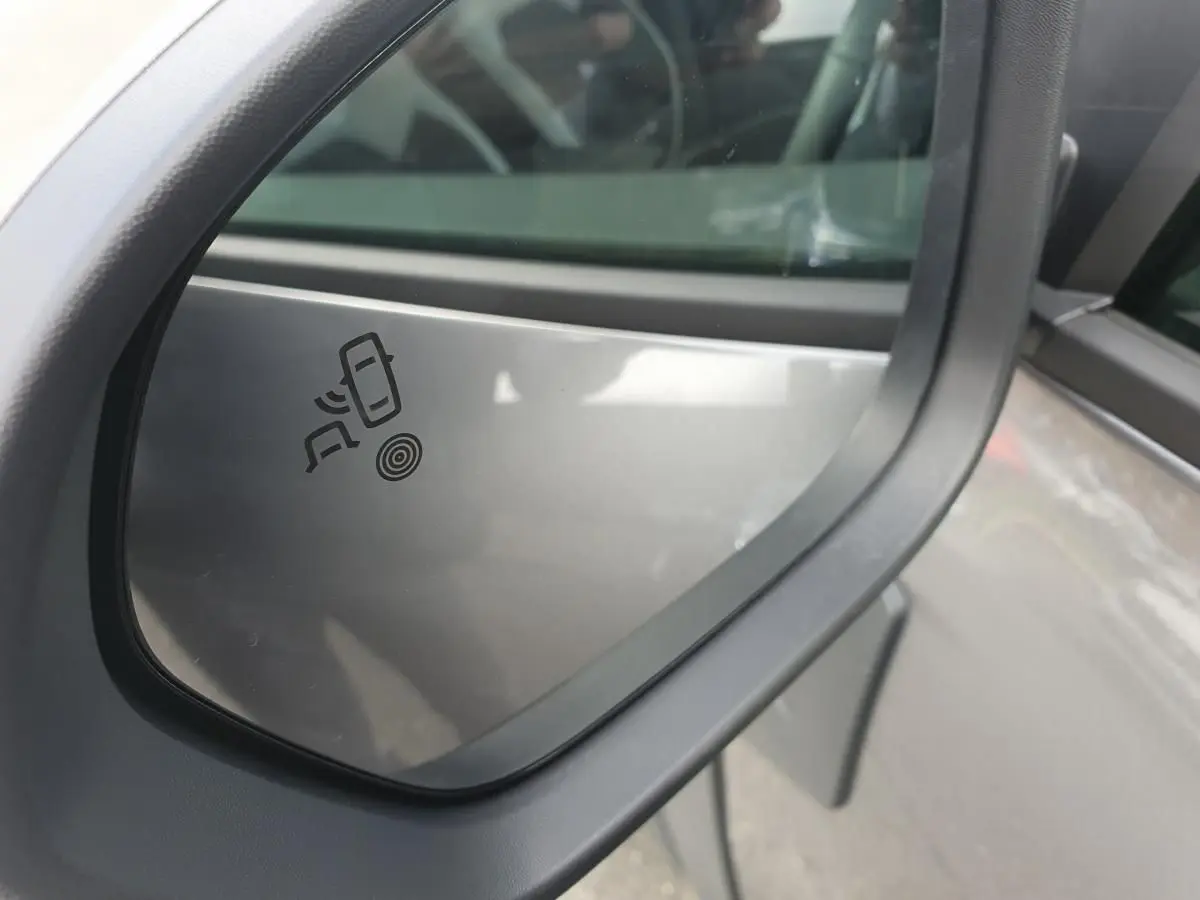 Rétroviseur côté droit du Dacia Dokker Van gris schiste 2026 avec icône d’alerte de changement de file visible.