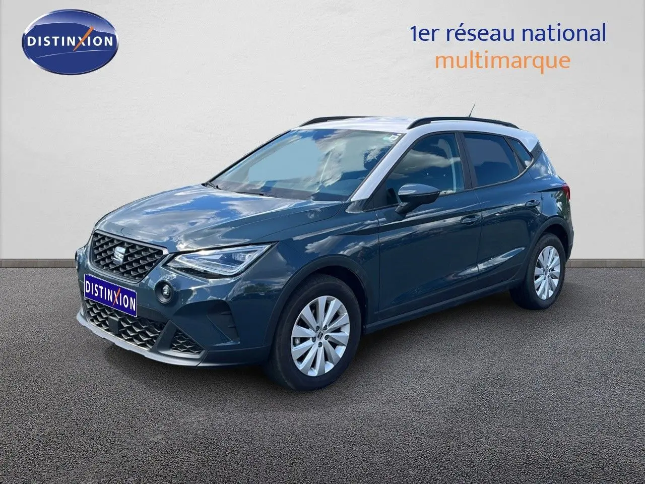 SEAT Arona bleu Fjord avec toit blanc, vue 3/4 avant droit, mettant en valeur ses lignes modernes et ses jantes argentées.