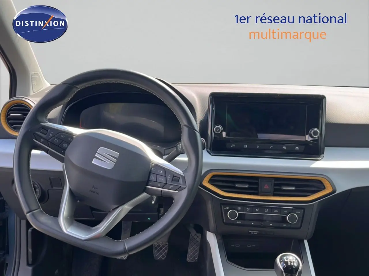 Vue intérieure du tableau de bord du SEAT Arona 2025, volant multifonction noir et console centrale avec écran tactile.