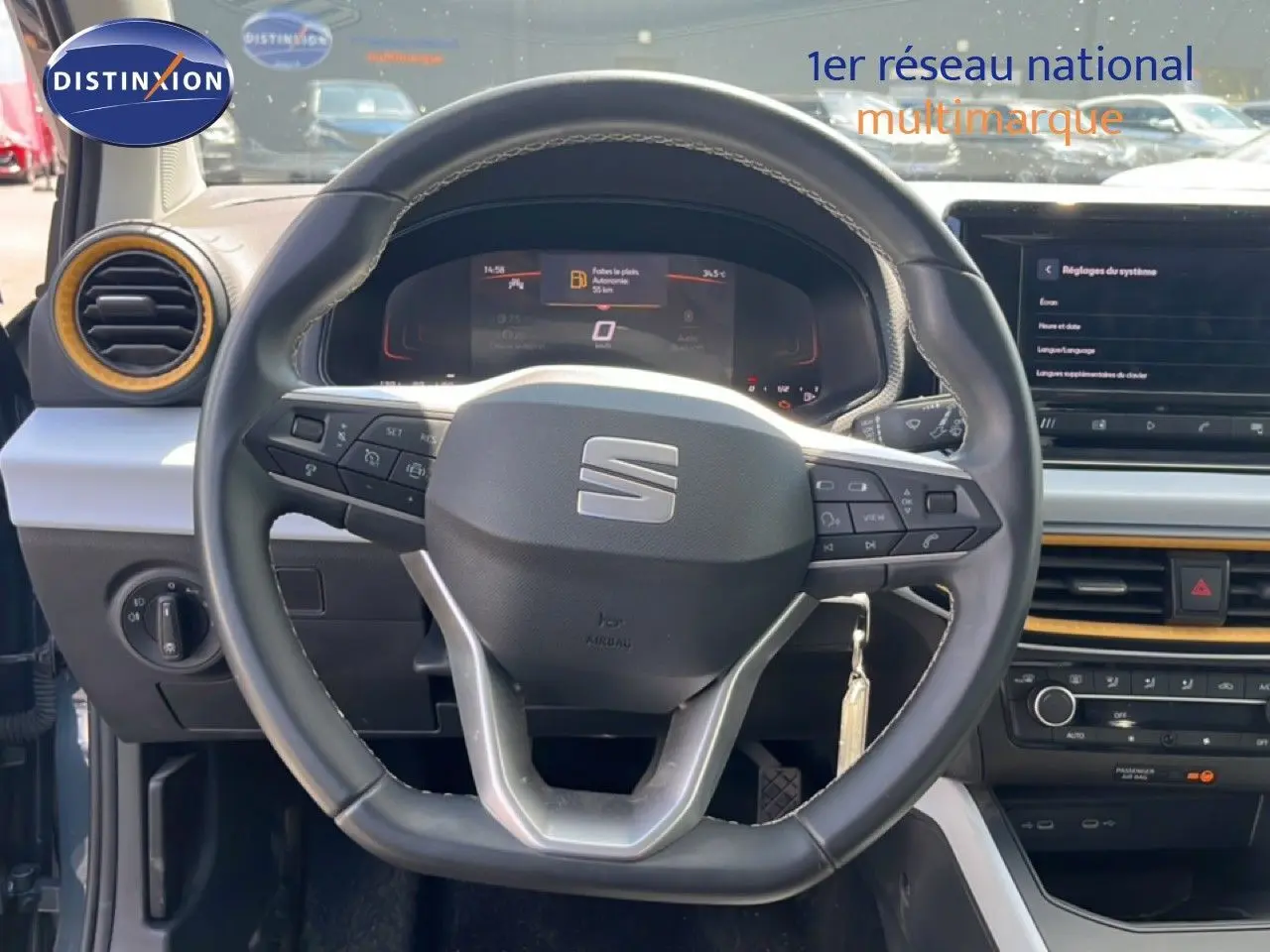 Vue rapprochée du volant et tableau de bord de la SEAT Arona 2025, intérieur gris avec inserts jaunes.