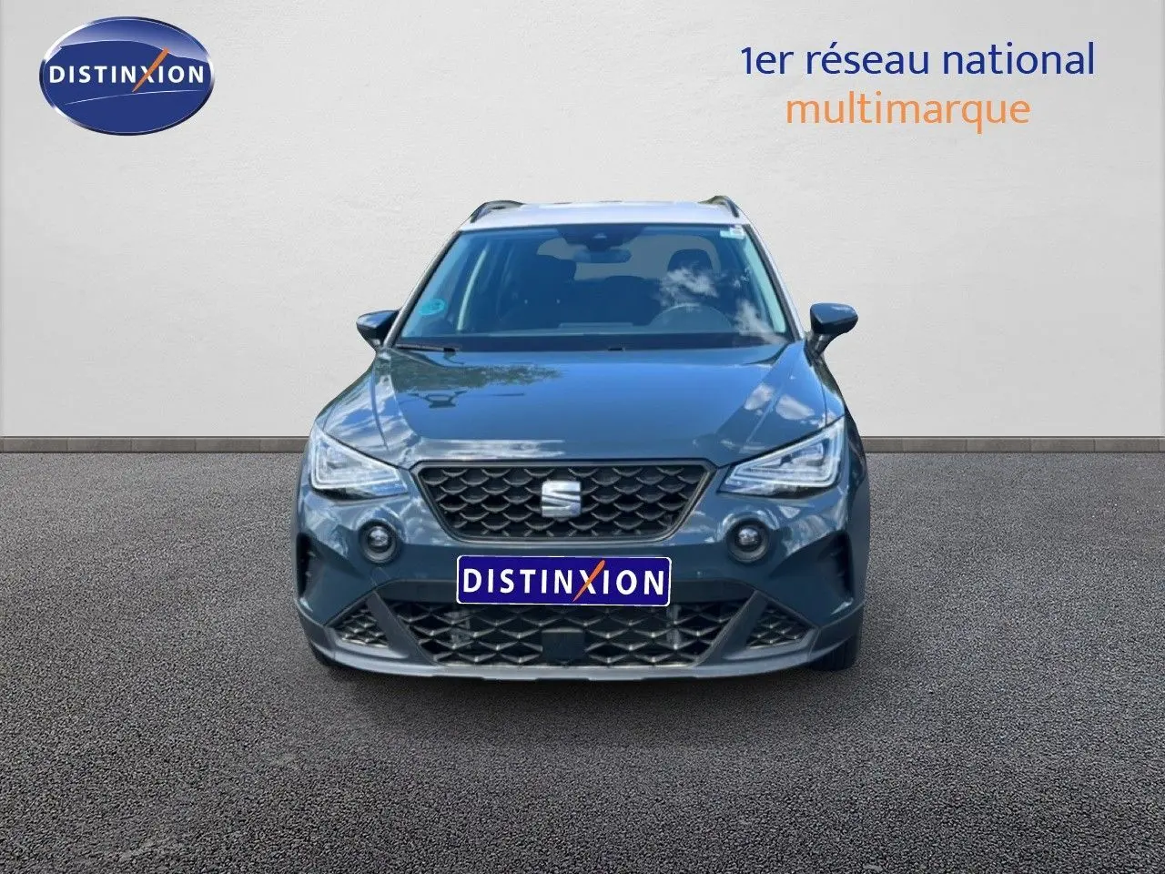 Vue frontale d'un SEAT Arona bleu Fjord avec toit blanc, mettant en valeur sa calandre et ses phares LED distinctifs.
