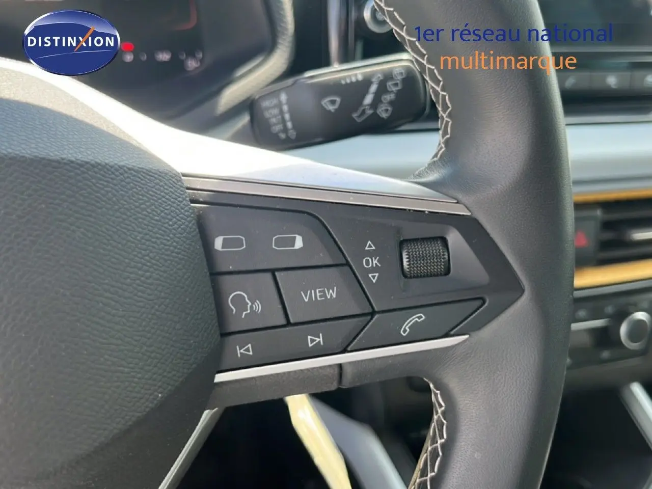 Gros plan sur le volant multifonction du SEAT Arona 2025, mettant en valeur les commandes intégrées et la finition noire.