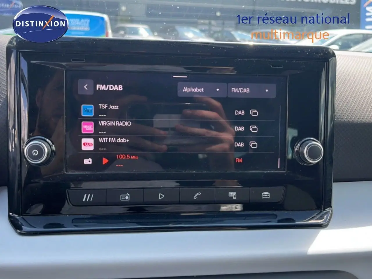 Écran tactile central du tableau de bord du SEAT Arona 2025 affichant les options radio FM/DAB en intérieur clair.