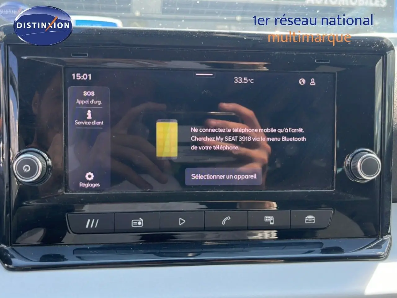 Écran tactile central du tableau de bord du SEAT Arona 2025, affichant le menu Bluetooth avec reflet des mains.