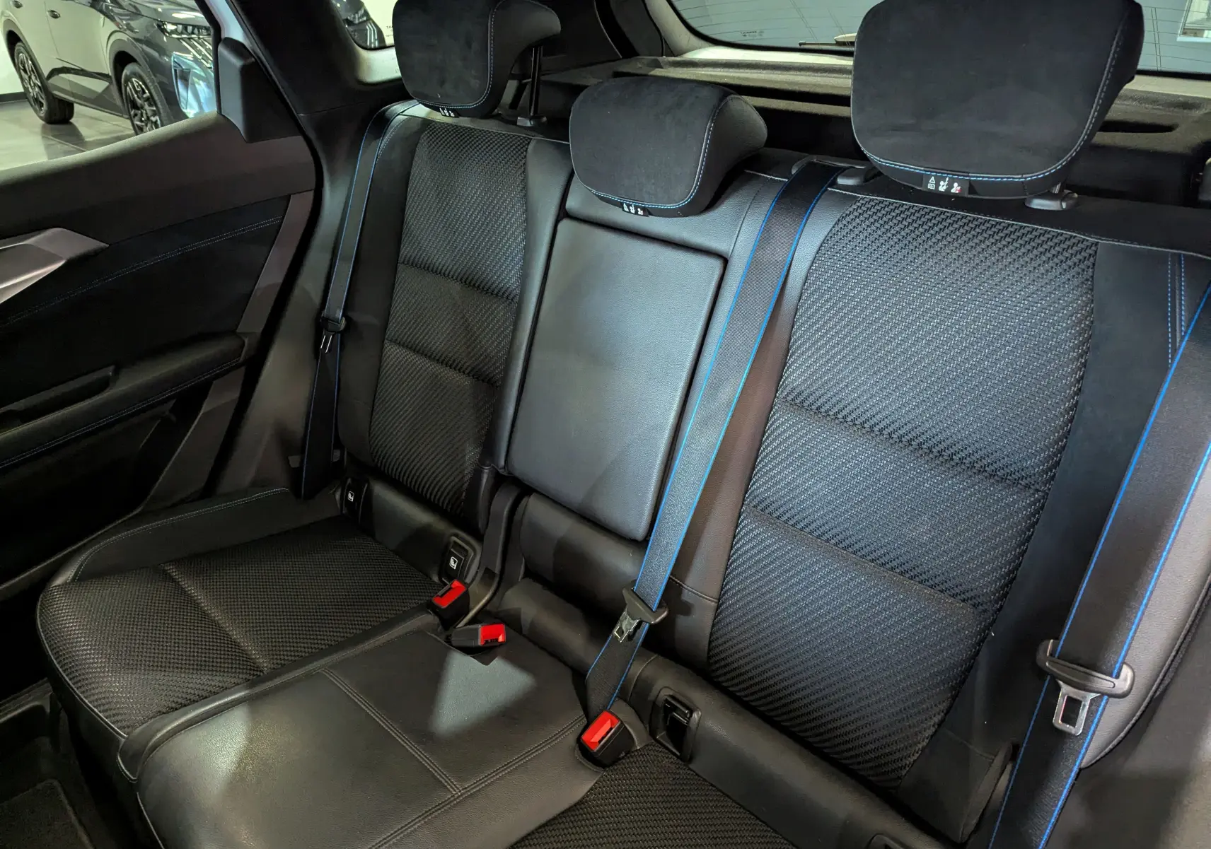 Vue intérieure sur la banquette arrière noire avec surpiqûres bleues du Renault Austral E-Tech 2023.