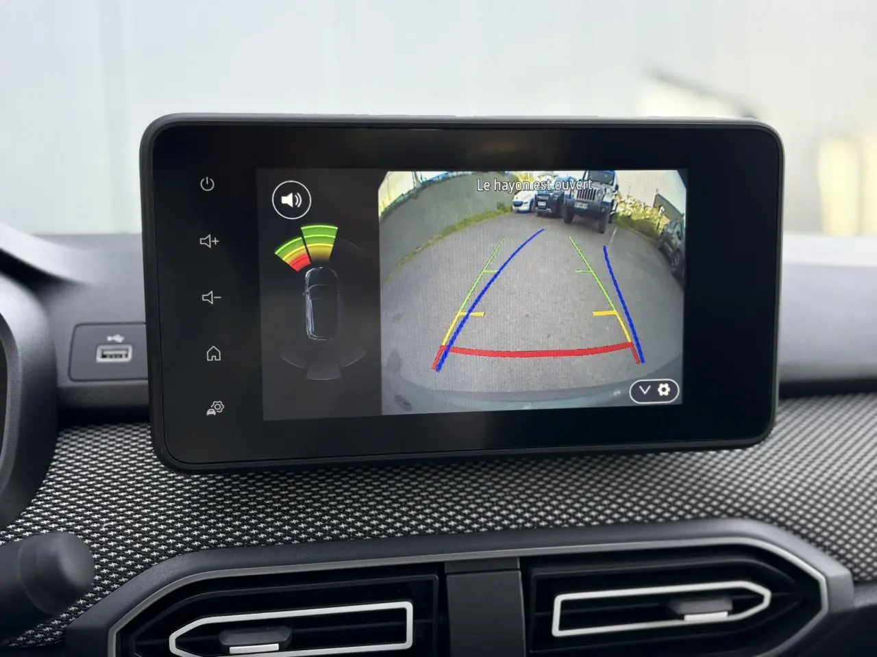 Écran tactile intérieur du Dacia Jogger affichant la caméra de recul avec guidage coloré et capteurs de proximité.
