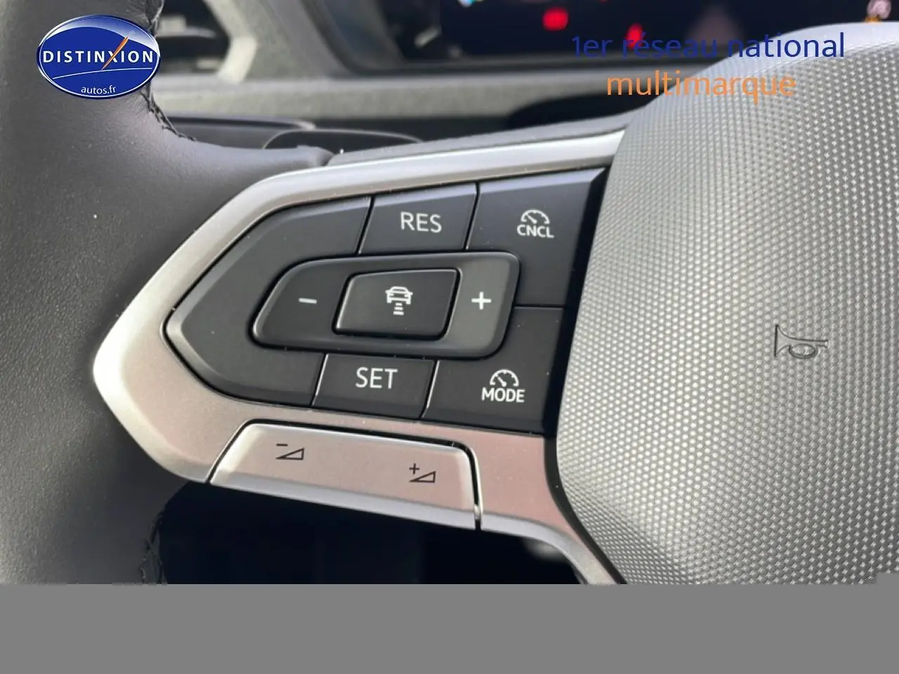 Gros plan sur les commandes du volant cuir multifonction du Volkswagen Caddy gris indien, avec régulateur adaptatif.