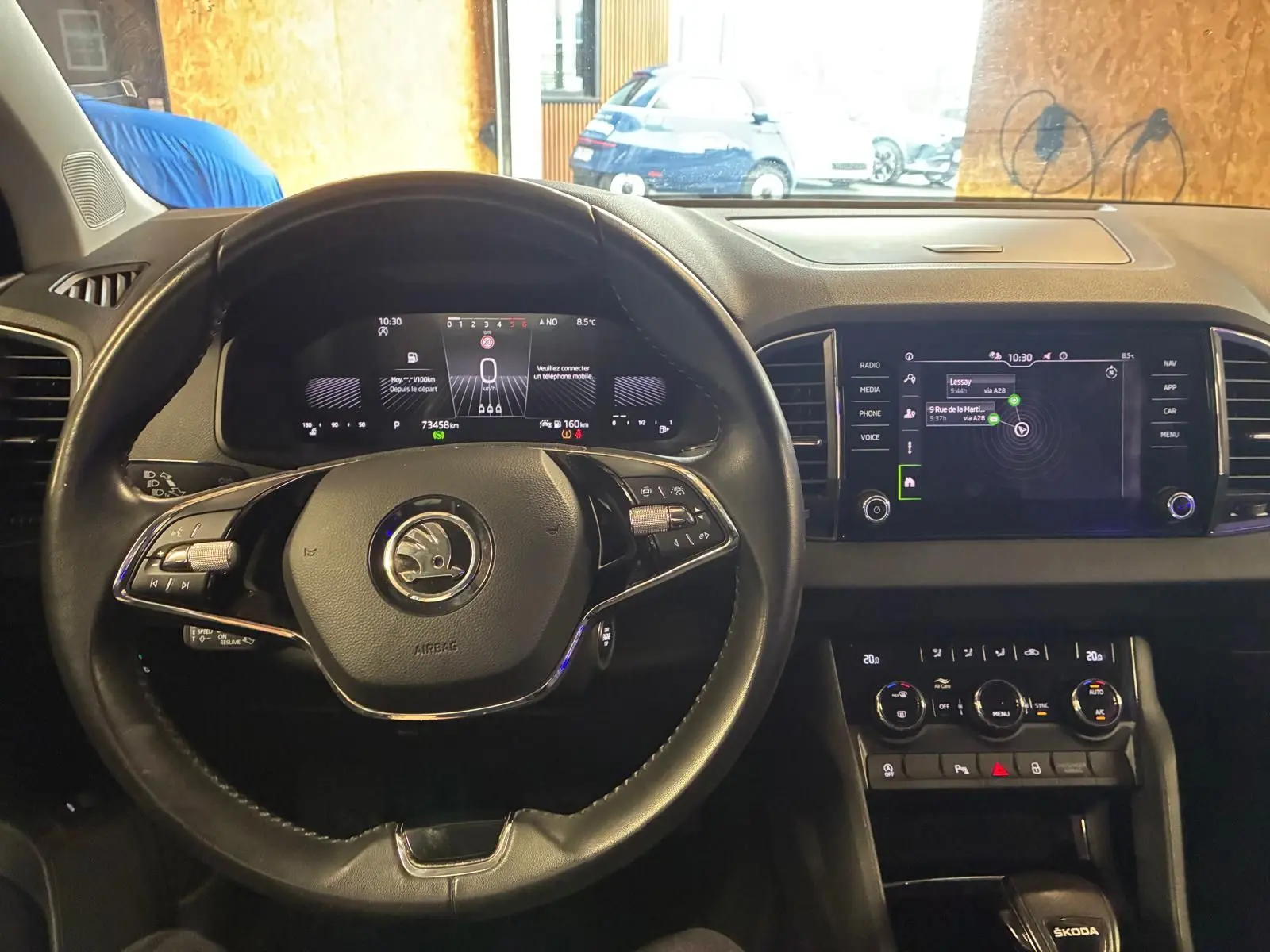 Vue intérieure du tableau de bord et volant noir du Skoda Karoq 2.0 TDI 115 DSG7 Business avec écran tactile et commandes au volant.