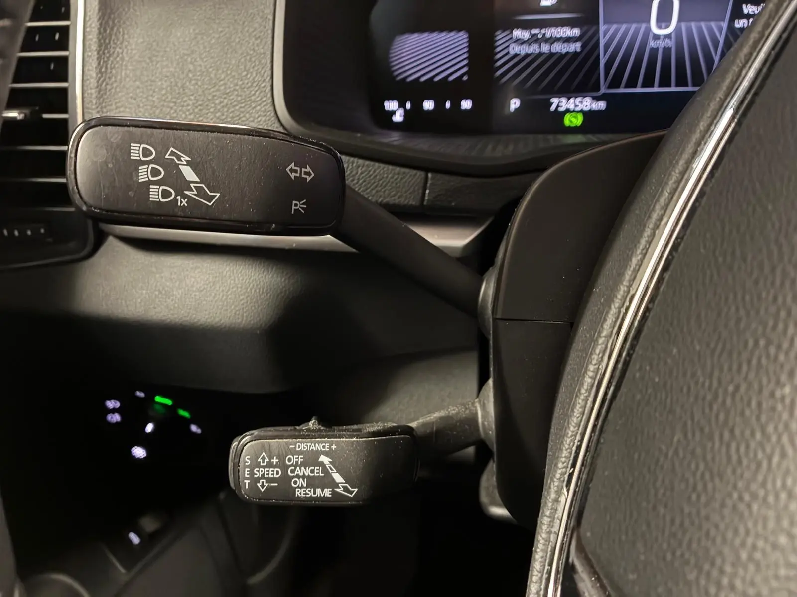 Gros plan sur les commandes au volant du Skoda Karoq noir 2023, avec leviers de clignotants et régulateur de vitesse.